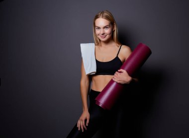 Salonunda egzersiz sonra bekletin. Oturma ve yoga ya da fitness sonra rahatlatıcı bir yoga mat ile spor spor güzel gülümseyen kadın.