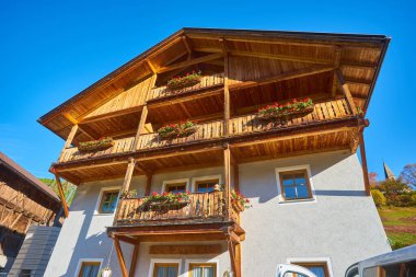 Modern ahşap alp biçimli balkon ve verniklenmiş tahta levhalar, kiremitler ve kerestelerle mimari