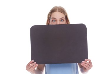 blonde girl peeking out from behind signboard with copy space. Studio shot on a white background.