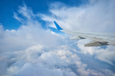 Uçak penceresinden bulutların üzerinde gün batımının muhteşem görüntüsü