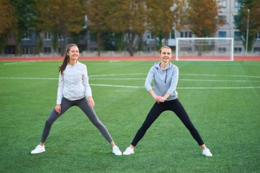 İki güzel kız birlikte bir çimenlikte sabahın erken saatlerinde egzersiz spor.