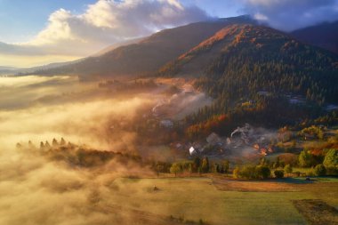 Sis şafakta dağların üzerine yayılır. Güneş ufuktan doğuyor. Sabah Ukraynalı Karpatlar. Hava aracı görünümü.