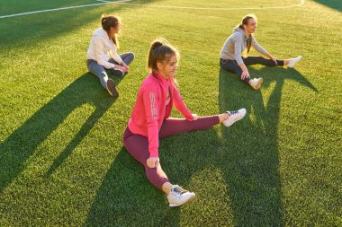 Pozitif kadın spor egzersizleri yapıyor... Üç güzel genç kadın spor güneşli bir günde parkta yapıyor grubu.
