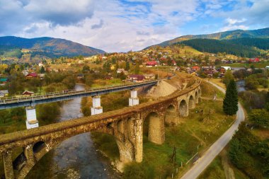İHA 'dan hava görüntüsü. Viaduct üzerindeki hava manzarası inanılmaz Vorokhta Ukrayna 'daki bir Avusturya taş kemer köprüsü. Karpat Dağları 'nda bulutlu bir sonbahar günü