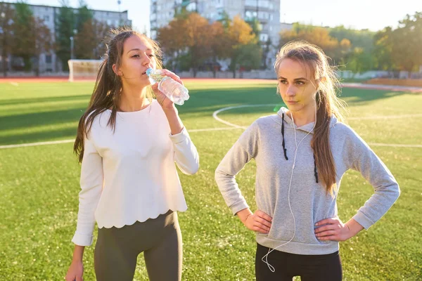 Δύο Γυναίκες Αθλητικό Στάδιο Μπουκάλια Νερό Ξεκουράζονται Μετά Από Προπόνηση — Φωτογραφία Αρχείου