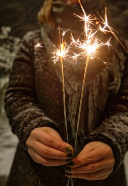 Maytap portre siyah arka plan üzerine el yanan yeni yıl partisi. Kadın ateş etmek parlayan parlayan tatil parlak el havai fişek, tutar. Noel ışık.