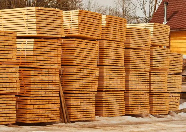 Wood boards piles stored outdoor, lumber storage. Stacked wooden boards at lumberyard. Stack of lumber at outdoor warehouse. Stockpiled boards