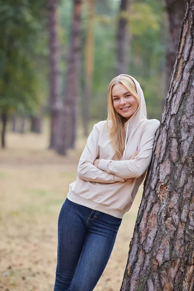 Atraktivní Modrooká Blondýnka Kráčí Městském Parku Dívka Nosí Béžovou Mikinu — Stock fotografie
