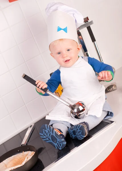 Pequeno chef bebê no chapéu do cozinheiro com concha de metal — Fotografia de Stock