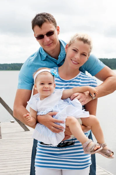 Happy family on the river bank — Stock Photo, Image