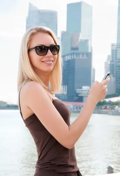 Hermosa joven con teléfono móvil en Singapur —  Fotos de Stock