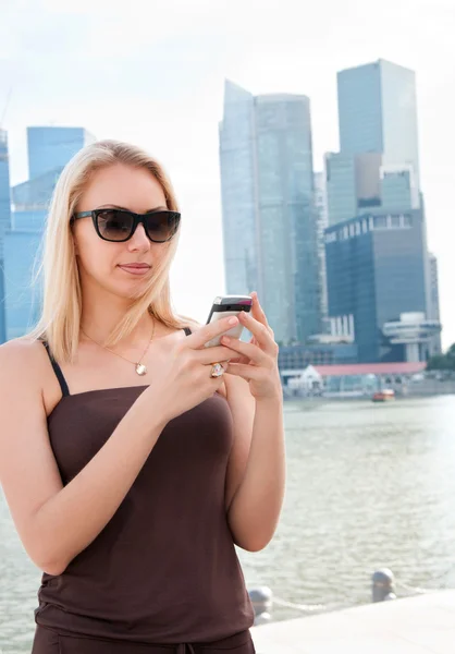 Красива молода жінка з мобільного телефону в Сінгапурі — стокове фото