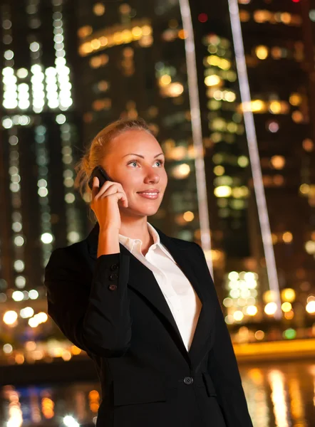 Souriant jeune femme d'affaires parlant au téléphone dans la grande ville — Photo