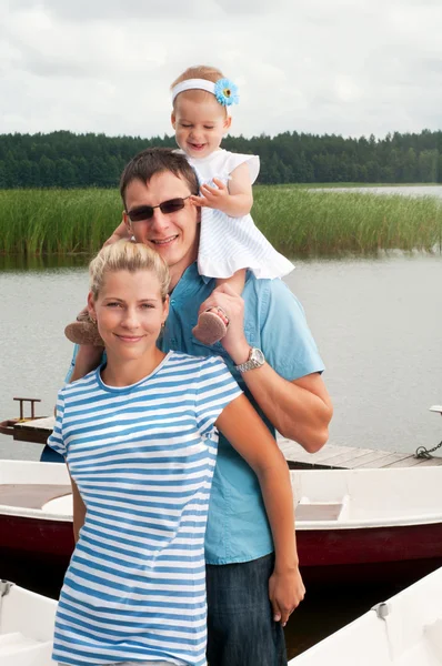 Happy family on the river bank — Stock Photo, Image