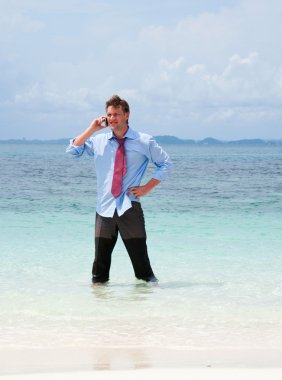 Sahilde cep telefon ederken iş adamı