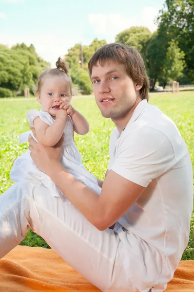 Młody szczęśliwy ojciec z córką w parku — Zdjęcie stockowe