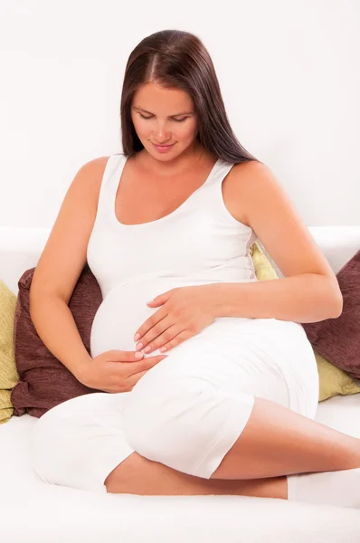 Femme enceinte se détendre à la maison sur le canapé — Photo