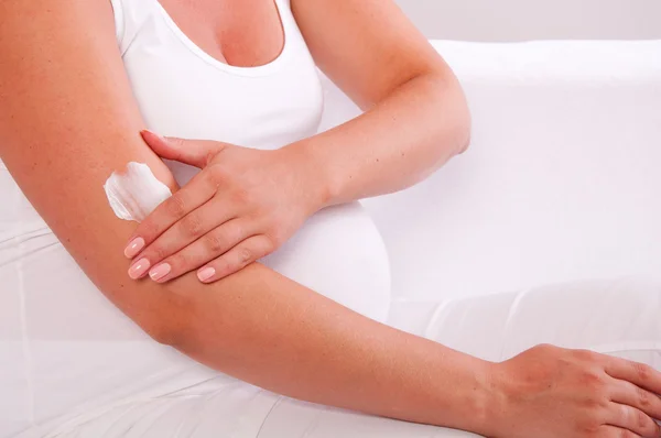 Pregnant woman applying cream on her body — Stock Photo, Image
