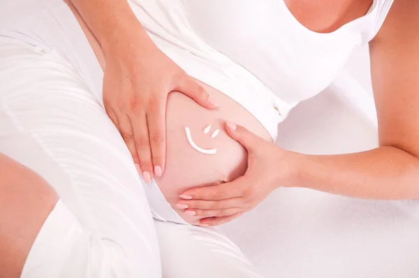 Barriga de mulher grávida com símbolo de sorriso nele — Fotografia de Stock
