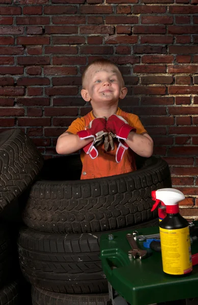 Cute and funny little mechanic with a tire — Stock Photo, Image