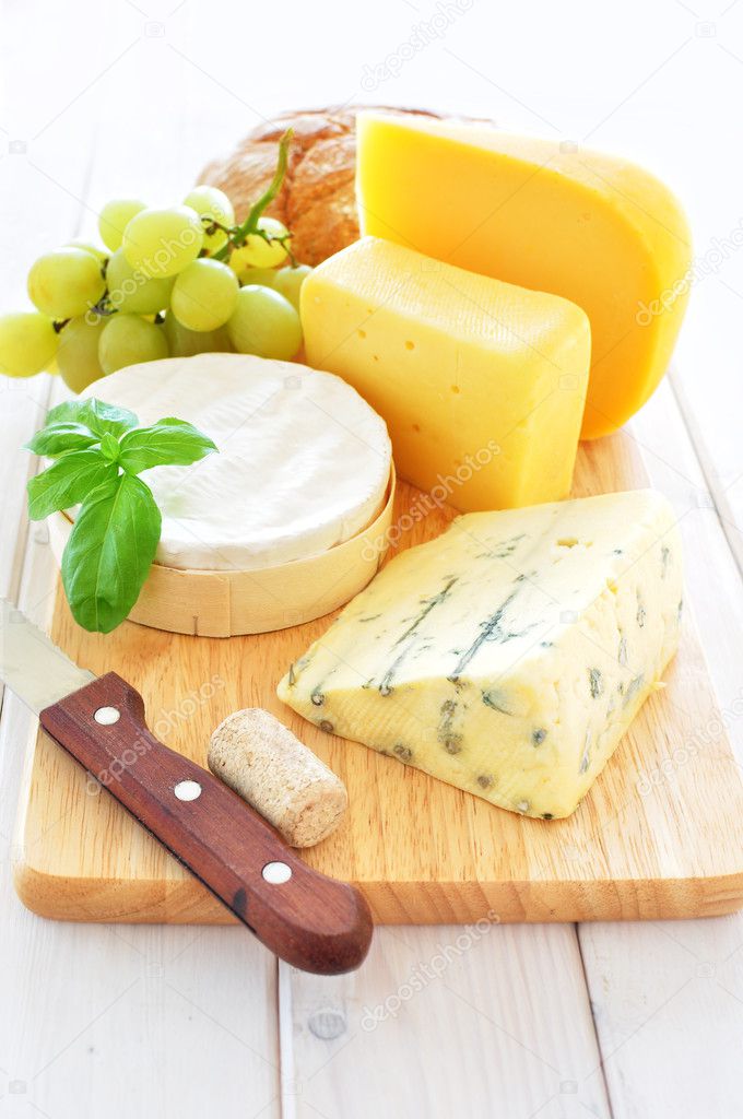 Assortment of cheese on a wooden platter — Stock Photo © VikaRayu 14565719