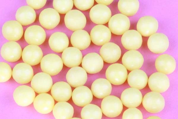 Yellow vitamins on pink background — Stock Photo, Image