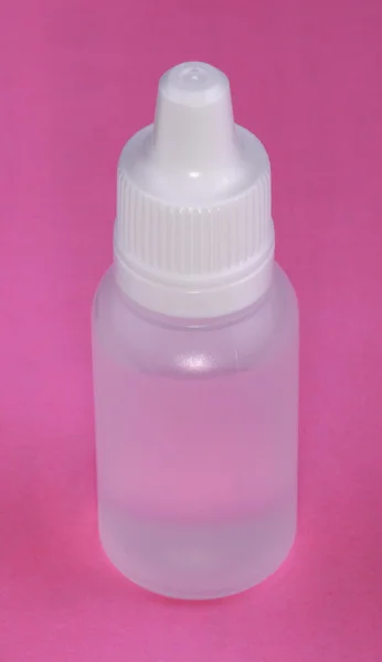 Белый пластиковый Vial на розовом фоне — стоковое фото