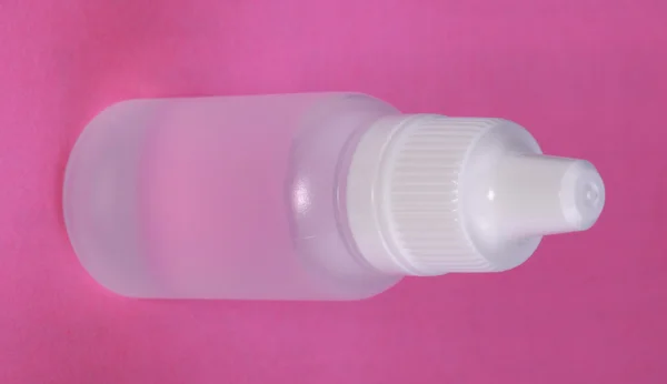 粉红色的背景上的白色塑料小瓶 — 图库照片