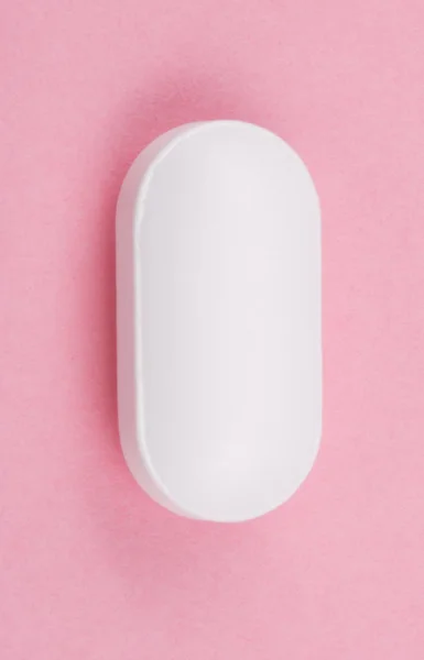 Pilule blanche sur fond rose — Photo