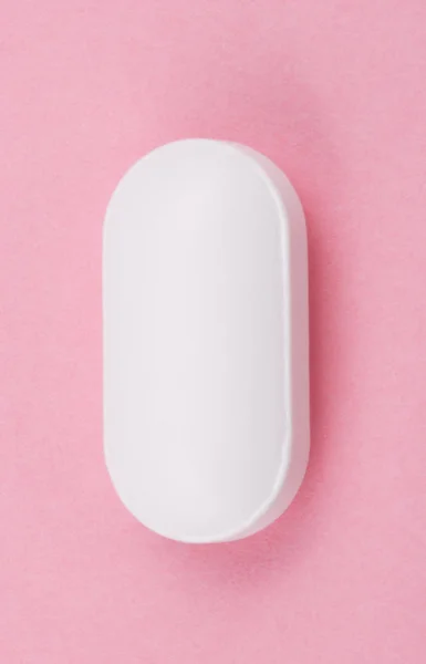 Pilule blanche sur fond rose — Photo