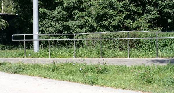 Güneşli yaz gününde parkta metal çitler