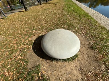 Kuru, güneşli sonbahar gününde parkta yuvarlak bir taş.