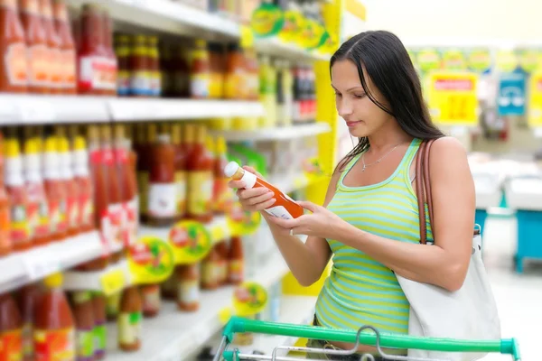 Frau überprüft Lebensmittelkennzeichnung Stockbild