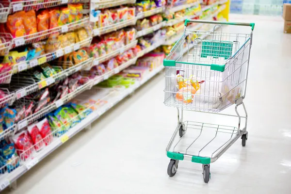 Shopping trolley in aisle of supermarket Stock Photo