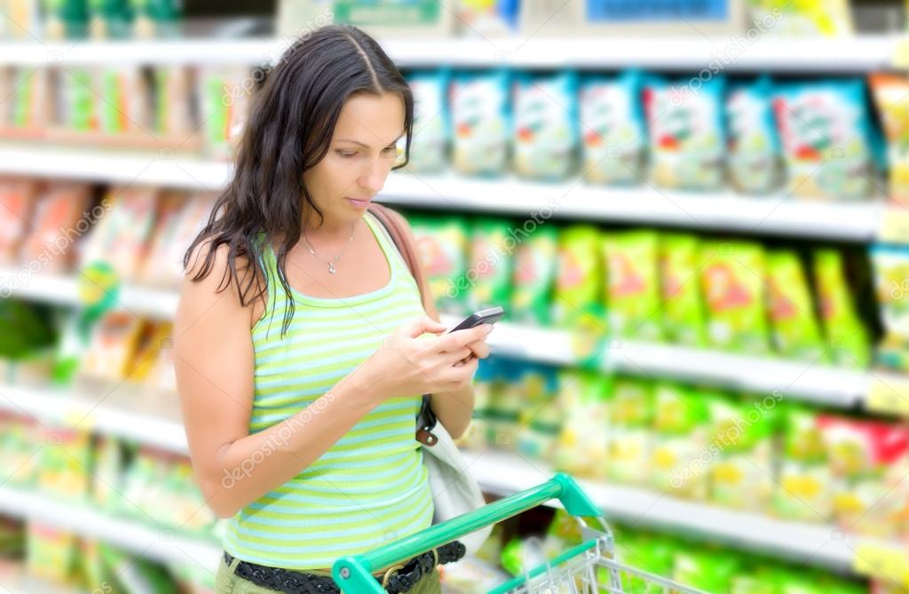 A woman reads SMS in supermarkets