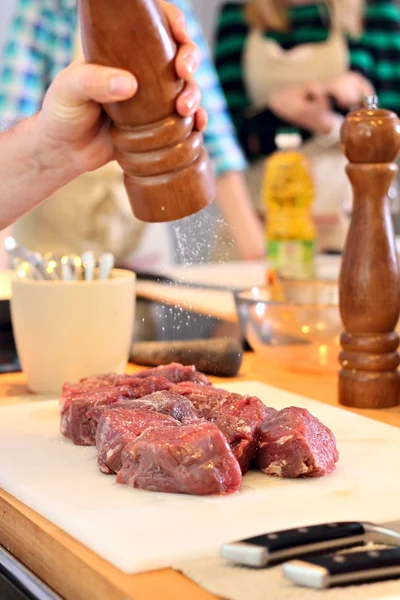 Man is salting a meat — Stock Photo, Image