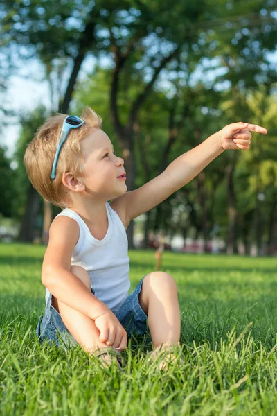 Küçük çocuk parkta oturan — Stok fotoğraf