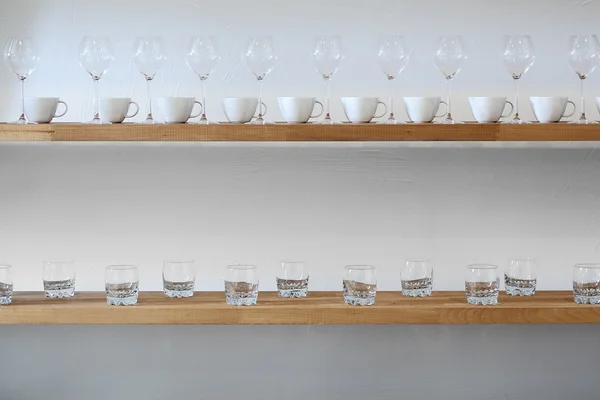 Cups and glasses on a shelf — Stock Photo, Image