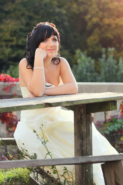 웨딩 드레스는 벤치에 앉아 있는 여자 스톡 사진