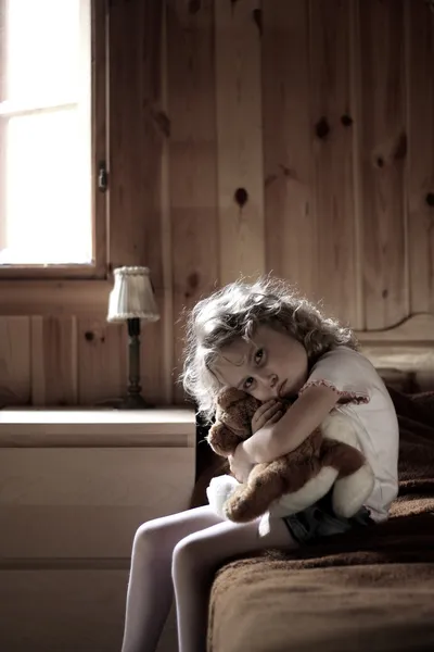 Triste niña abrazando oso de peluche —  Fotos de Stock