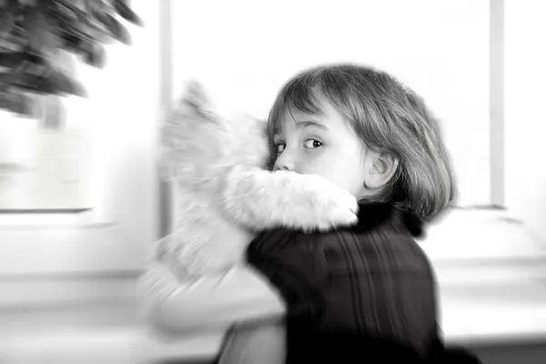 Испуганная маленькая девочка обнимает плюшевого мишку — стоковое фото