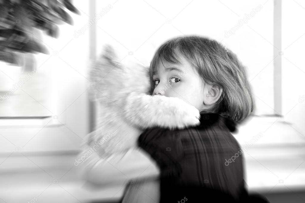 Frightened little girl hugging teddy bear