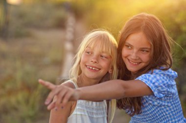 İki tatlı genç kız dışarıda gülüyor. 