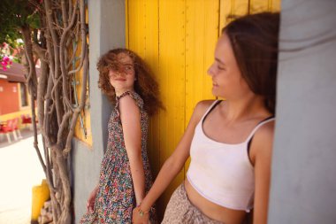 İki genç arkadaş yürüyor ve gülüyor. 