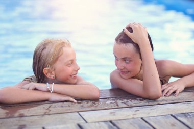 Kız arkadaşlar yaz tatilinde havuzda eğlenirler. 