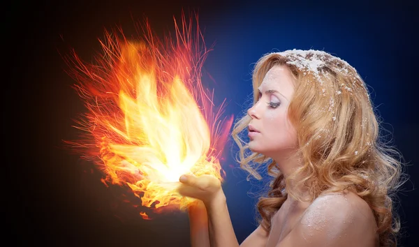 Gefrorenes Mädchen hält einen Falme in den Handflächen — Stockfoto