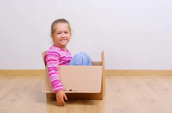 Nieuwsgierig meisje in kartonnen doos — Stockfoto