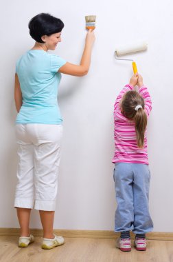 genç bir kadın ve küçük kızı boyama araçları ile