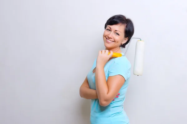 Mujer joven con rodillo de pintura — Foto de Stock