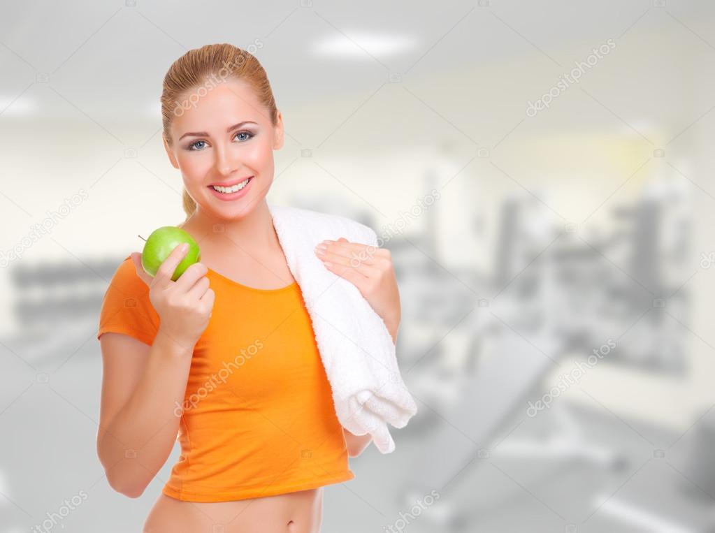 Young woman with green apple and towel